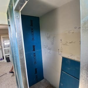 קיר גבס עם לוחות כחולים וכתיבה על הקיר