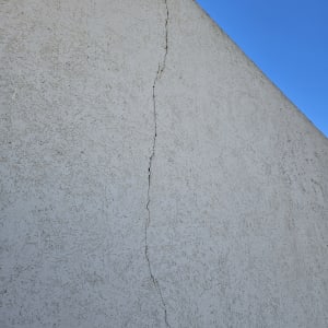 סדק בקיר חיצוני תחת שמיים כחולים