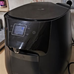 מכשיר חשמלי שחור עם מסך מגע במטבח