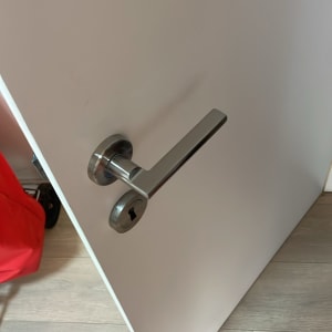 ידית דלת מתכתית על דלת לבנה