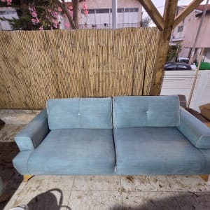 ספה כחולה על רצפת מרפסת עם גדר במבוק