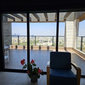 מרפסת עם נוף עירוני דרך חלון זכוכית