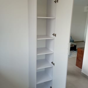 ארון לבן עם דלת פתוחה ומדפים פנימיים