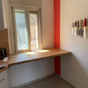 שולחן עץ עם סכינים על הקיר במטבח