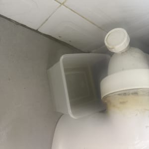 כיור עם צינור פלסטיק ודלי קטן לידו