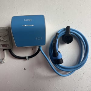 מטען לרכב חשמלי מותקן על קיר עם כבל טעינה כחול