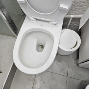 אסלה פתוחה עם מים על הרצפה ליד