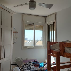 מאוורר תקרה מותקן בחדר שינה קטן.