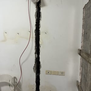 כבלים חשמליים בקיר פתוח עם שקית פלסטיק