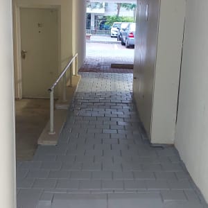 רמפה עם מעקה מתכת ודלת בצד שמאל