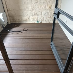 מרפסת עם דק עץ ודלת זכוכית פתוחה