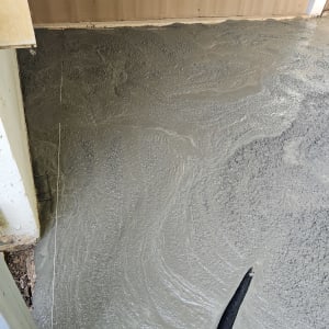 רצפת בטון טרי עם צינור שחור בתהליך יציקה