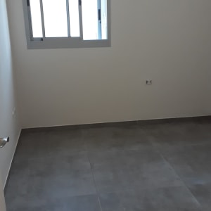 חדר ריק עם רצפה נקייה וחלון פתוח