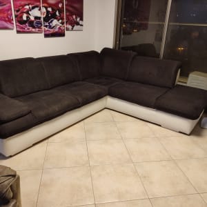 ספה פינתית עם ריפוד כהה על רצפת אריחים