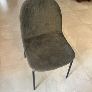 כיסא מרופד בבד ירוק כהה על רצפת שיש