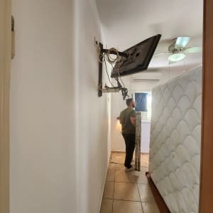 אדם צובע קיר בעזרת רולר ומגש צבע