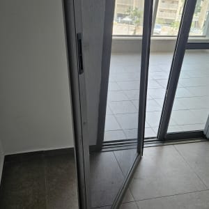 דלת זכוכית עם תריסים במרפסת בניין