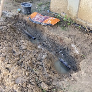 חפירה באדמה עם צינור מים חשוף ודלי