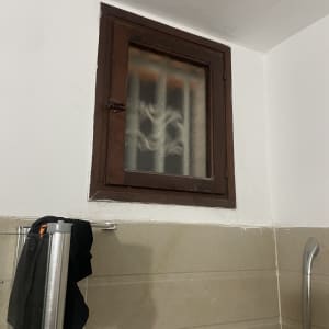 חלון זכוכית קטן עם מסגרת עץ בחדר אמבטיה