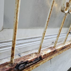 חלון עם סורגים חלודים ומסילה
