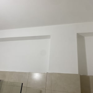 קיר עם אריחים לבנים ותקרה לבנה