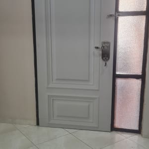 דלת עם ציפוי מתכת ומנעול כסוף ליד חלון זכוכית