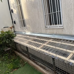 מבנה עץ עם כיסוי פלסטיק ליד קיר חיצוני