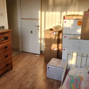 קופסאות קרטון מסודרות ליד מיטה בחדר שינה