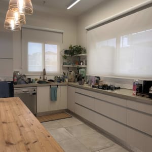 מטבח עם וילונות גלילה לבנים על החלונות