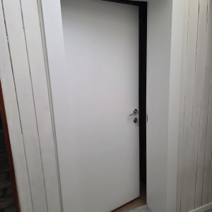 דלת לבנה עם ידית כסופה פתוחה מעט