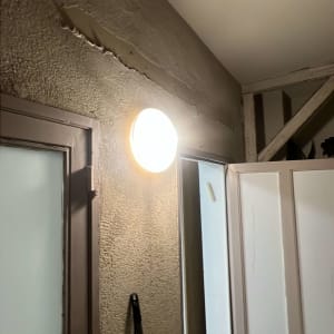 מנורה מותקנת על קיר עם טיח מתקלף