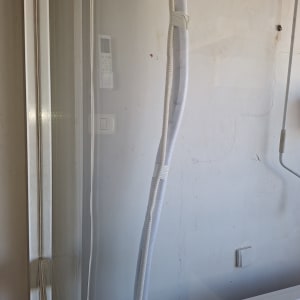 צנרת מיזוג אוויר עטופה וצינור ניקוז כחלק מהתקנת מזגן