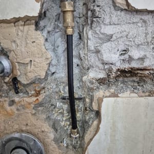 צינור מים חשוף בקיר עם חיבורי מתכת