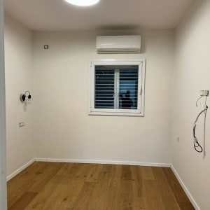 חדר עם קירות צבועים בלבן ותאורה עליונה