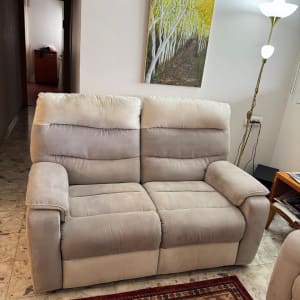 ספה אפורה בחדר מגורים עם שטיח ותמונה על הקיר