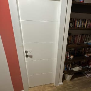 דלת לבנה עם ידית כסופה בחדר עם מדף ספרים