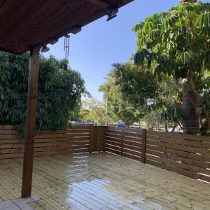 דק עץ עם גדר עץ וצמחייה מסביב