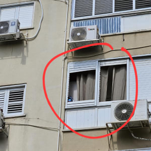 תריסים וחלונות עם מזגנים על קיר בניין