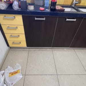 ארונות מטבח עם כלים וחפצים על השיש