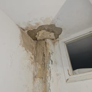 קיר עם סימני רטיבות והתקלפות צבע