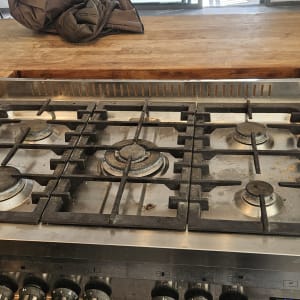 כיריים גז עם חמישה מבערים על משטח עץ