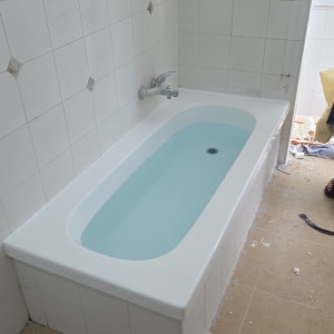 אמבטיה עם אריחים לבנים ועבודת שיפוץ