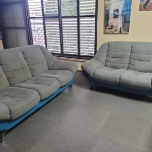 שתי ספות אפורות בחדר עם רצפת אריחים