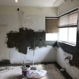 קירות מטויחים, דלי צבע, מטאטא, חלון עם תריסים