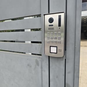 מערכת אינטרקום מותקנת על שער מתכת אפור