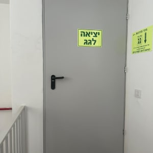 דלת אפורה עם שלט יציאה לגג