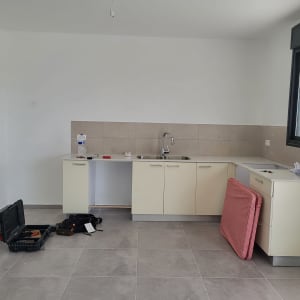 מטבח עם ארונות, כיור, כלים ותיק כלים פתוח