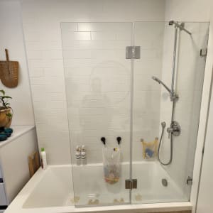 מקלחת עם דלת זכוכית, ראש מקלחת ומוצרי טיפוח