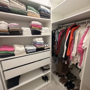 ארון בגדים מסודר עם בגדים מקופלים ותלויים