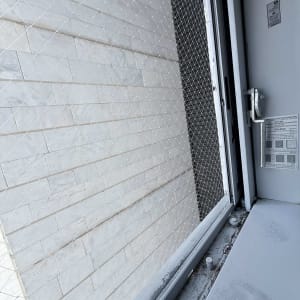התקנת רשת שקופה נגד יונים על פתח חלון בבניין מגורים